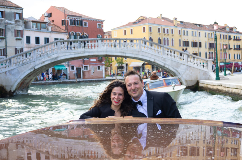 Coppia felice in motoscafo a Venezia durante un fidanzamento romantico