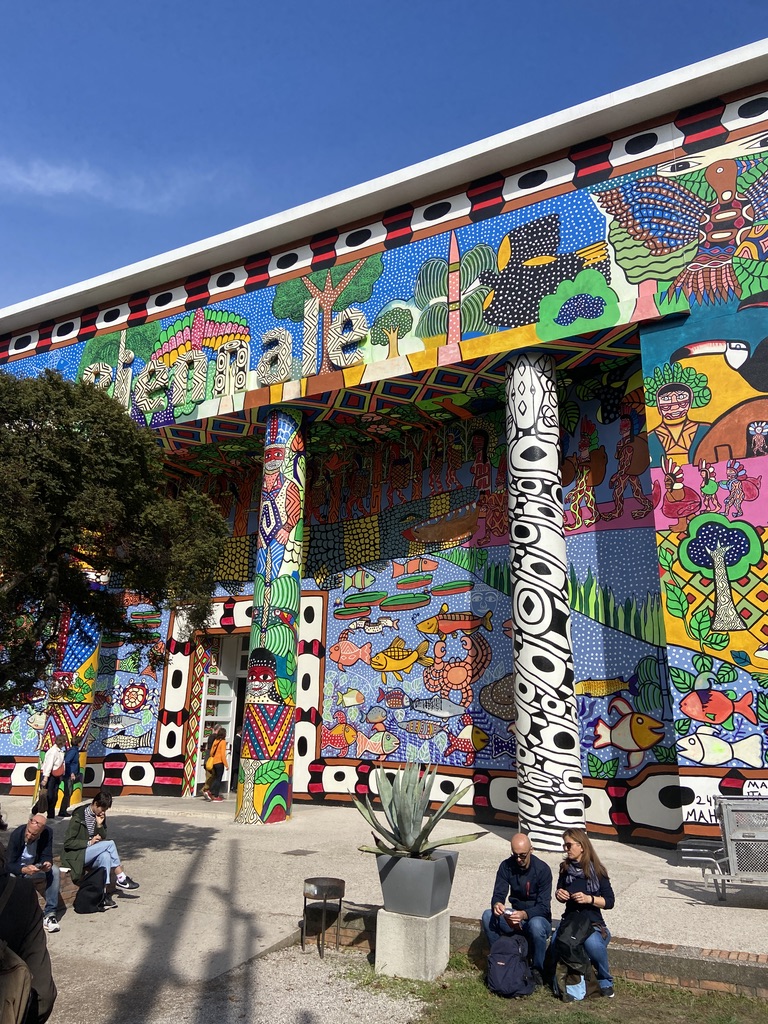 Facciata colorata del padiglione della Biennale di Venezia con murales contemporanei e visitatori all’ingresso