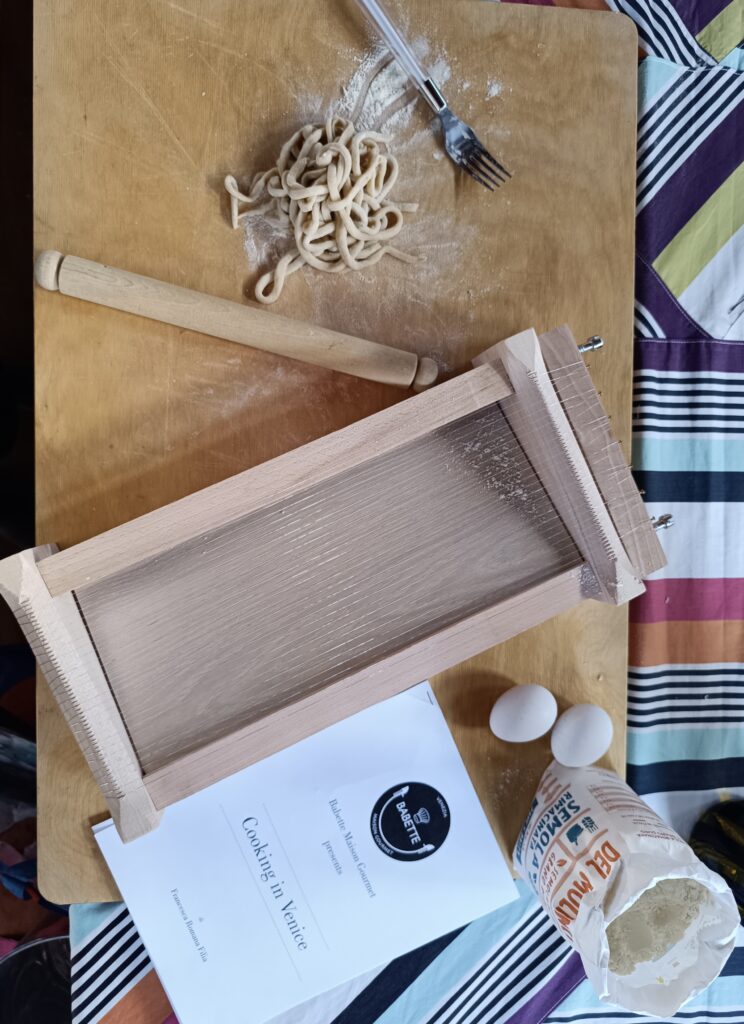 Sfide culinarie a Venezia durante una cooking competition di team building con pasta fresca fatta a mano