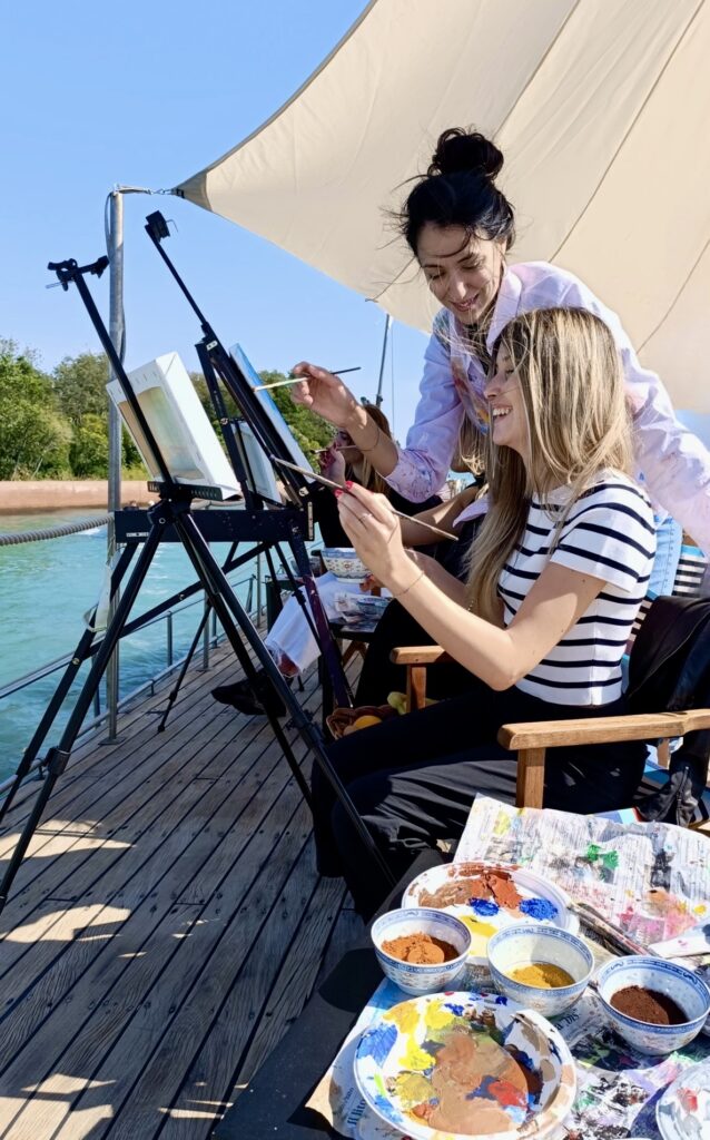 Pittura in barca a Venezia con artista e partecipanti che dipingono la laguna