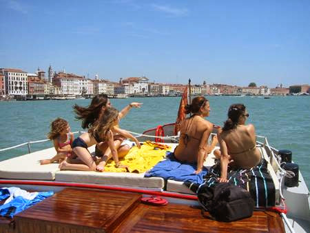 Gruppo di ragazze in barca a Venezia durante un addio al nubilato sul Canal Grande
